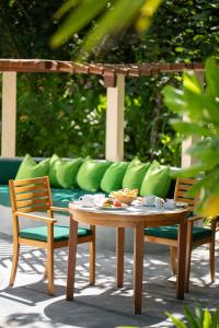 a table and two chairs and a couch at Coco Palm Dhuni Kolhu in Thulhaadhoo