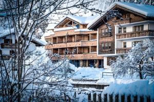 a building covered in snow next to a fence at HAUSEREI am Lech in Steeg