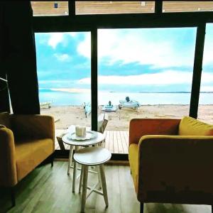 - un salon avec une table et une vue sur la plage dans l'établissement BEACH HOUSES, à Tuzla