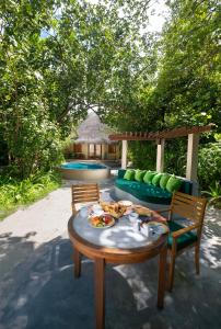 d'une table avec une assiette de nourriture au-dessus dans l'établissement Coco Palm Dhuni Kolhu, à Thulhaadhoo