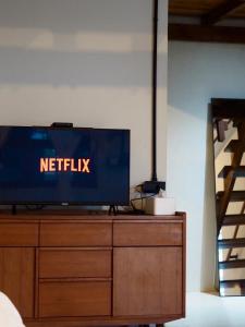 a television on top of a wooden dresser at Makai NAP in Ban Lam Pi