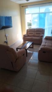 uma sala de estar com dois sofás e uma mesa de centro em Nyali cozy home em Mombasa