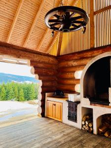 a fireplace in a log cabin with a ceiling at Fifth Element Retreat in Borzont
