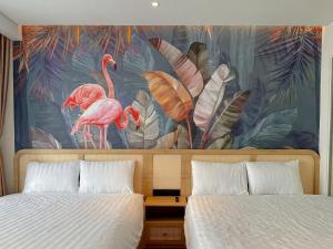 sypialnia z 2 łóżkami i malowidłem flamingów w obiekcie Mia Apec Mandala Phú Yên w mieście Tuy Hòa
