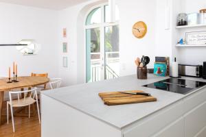 eine Küche mit einer weißen Arbeitsplatte und einem Holzschnitttafel in der Unterkunft Ferienhaus Luv und Meer in Warnemünde