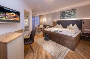 a bedroom with a large bed and a living room at Boutique Hotel Martha in Zell am See