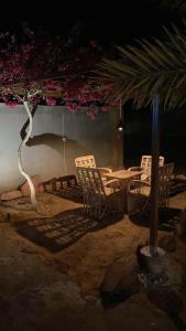 een groep stoelen en een tafel en een boom bij Mountain house in Al Ula