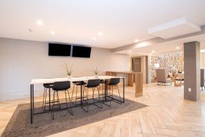 a living room with a table and chairs at Sandman Hotel Calgary Airport in Calgary