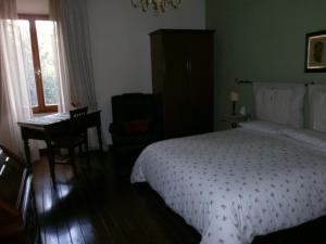 a bedroom with a bed and a desk and a window at Dimora Giosafatti in Ascoli Piceno