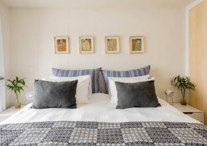 a bedroom with a white bed with blue and white pillows at Plett Holiday Apartment in Plettenberg Bay
