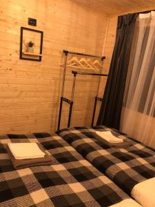 a bedroom with a bed with a checkered floor at Zustrizh u Leva in Pilipets