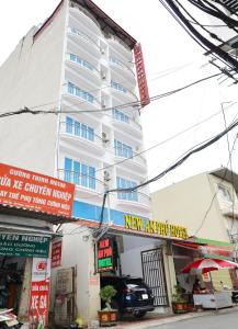 a white building with signs in front of it at New An Phú Hotel in Dong Anh