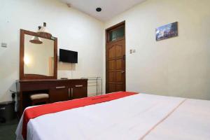 um quarto com uma cama, uma cómoda e um espelho em RedDoorz Plus @ Laweyan em Surakarta