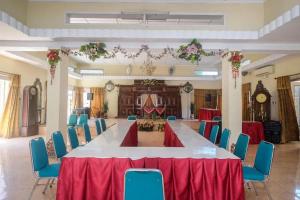 uma grande sala de conferências com uma mesa longa e cadeiras azuis em RedDoorz Plus @ Laweyan em Surakarta