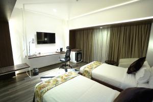 a hotel room with two beds and a television at Grand River View Hotel - Rajshahi in Rājshāhi