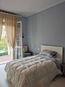 - une chambre avec un grand lit et une grande fenêtre dans l'établissement LA CASA DI GIM, à Lugo