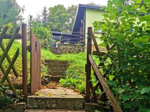 a wooden gate leading to a garden with stairs at Ferienhaus "Hasselstieg" in Stiege
