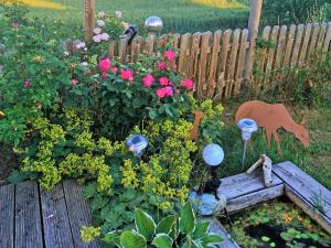 d'un jardin avec des fleurs et une clôture en bois. dans l'établissement Ferienhaus "Hirschsieh", à Stiege