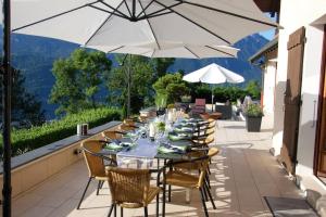 a table with chairs and an umbrella on a patio at Beautiful French mountain home in Marignier