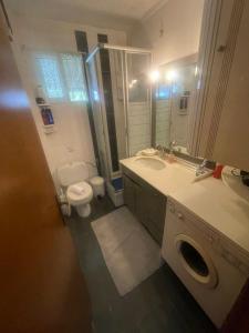 uma casa de banho com um WC, um lavatório e um espelho. em Elani Sea View em Elani