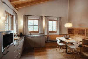 a kitchen with a table and a dining room at Villa Flora Mountain Lodges in San Cassiano