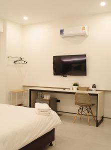 - une chambre à l'hôpital avec un lit et un bureau dans l'établissement Now Hostel, à Ban Chang