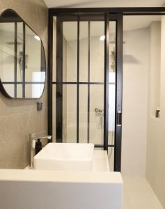 bagno con lavandino bianco e specchio di Now Hostel a Ban Chang