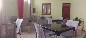 a dining room with chairs and a table and a table and chairsktop at SEED HOTEL in Entebbe