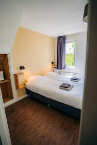 Schlafzimmer mit einem großen Bett und einem Fenster in der Unterkunft B&B de Luwte Cottage in Zwolle