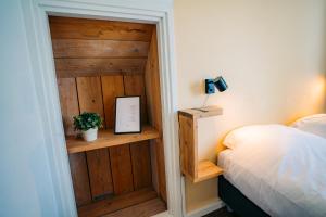 a bedroom with a wooden door and a bed at B&B de Luwte Cottage in Zwolle