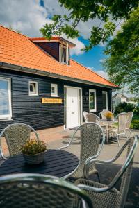 un patio con sillas, una mesa y un edificio en B&B de Luwte Cottage, en Zwolle