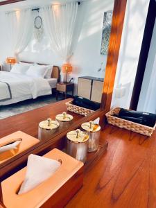 Ocean Pie Phuket في شاطئ راوايْ: غرفة فندقية بسرير وطاولة وكراسي
