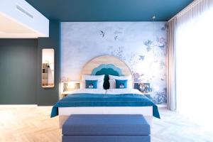 Schlafzimmer mit einem Bett mit blauer Wand in der Unterkunft the niu Flower in Konstanz