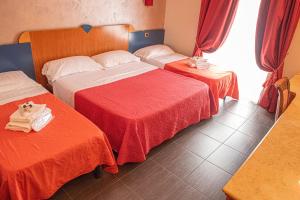 Habitación de hotel con 2 camas con sábanas rojas en Hotel Bellavista, en Marina di Varcaturo