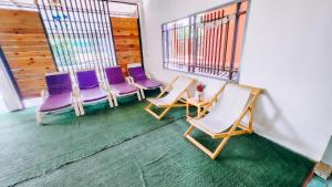 Downtown Kohlarn Resort في كو لان: مجموعة من الكراسي في غرفة بها نوافذ