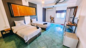 1 Schlafzimmer mit 2 Betten und blauem Boden in der Unterkunft Downtown Kohlarn Resort in Ko Larn
