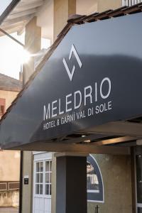Un cartello per un hotel Melffeno e un rivenditore di grano vale van di Hotel garni Meledrio a Dimaro