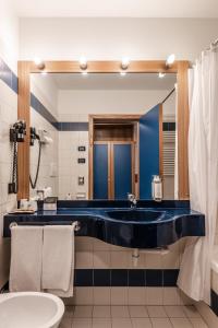 un bagno con una grande vasca blu di fronte a uno specchio di Hotel garni Meledrio a Dimaro