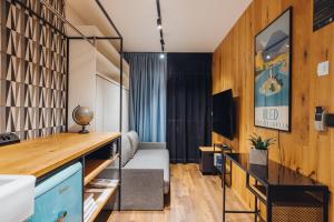 sala de estar con sofá y TV en City Glamping by ONE66 Hotel, en Liubliana