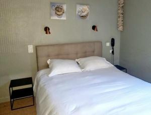 a bedroom with a large white bed with two pillows at The Originals Boutique, Hôtel La Villa Marine, Le Tréport in Le Tréport