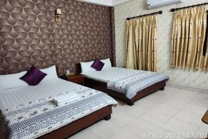- 2 lits dans une chambre d'hôtel avec des oreillers violets dans l'établissement BAU CAT HOTEL, à Hô-Chi-Minh-Ville