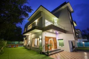 a large white house with a lawn in front of it at IN 4BHK VILLA LONAVALA in Lonavala