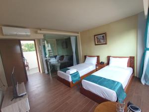 a hotel room with two beds and a living room at The Culture Hotel And Gallery in Bogor