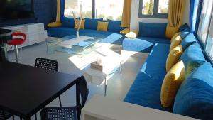een woonkamer met een blauwe bank en een tafel bij Duplex Deluxe Arous Al Bahr in Tanger