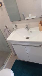 een badkamer met een witte wastafel en een spiegel bij Duplex Deluxe Arous Al Bahr in Tanger