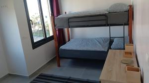 a small room with a bunk bed and a table at Duplex Deluxe Arous Al Bahr in Tangier