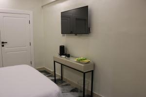 um quarto com uma cama e uma televisão na parede em Amman Trail Hotel & Studios em Amã