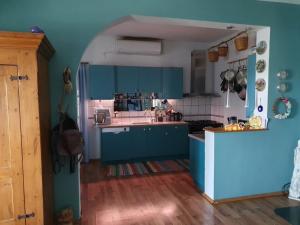 une cuisine avec des placards bleus et un comptoir dans l'établissement AGERAKI, à Lipsi