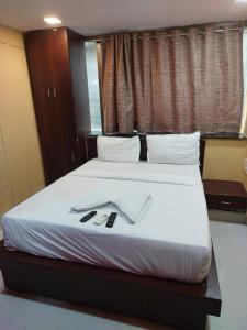 a bedroom with a bed with two utensils on it at ARTUS HOTEL in Mumbai