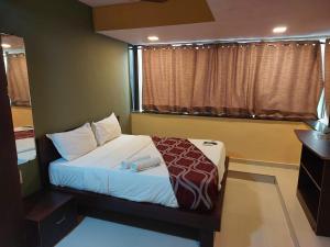 a bedroom with a bed and a window at ARTUS HOTEL in Mumbai